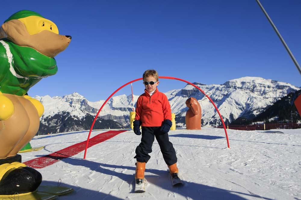 Kind auf Ski im Kinderland