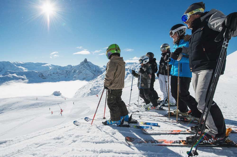 Skifahrer auf der Piste mit Bergpanorama