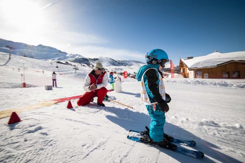 Kinder mit Skifahrer im Kinderland