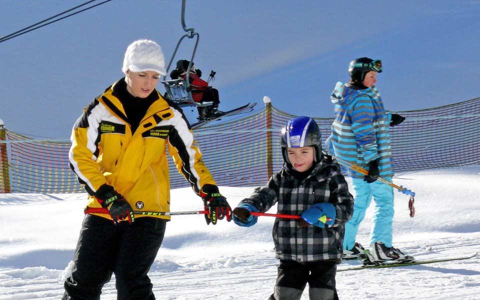 Skilehrer mit Kind