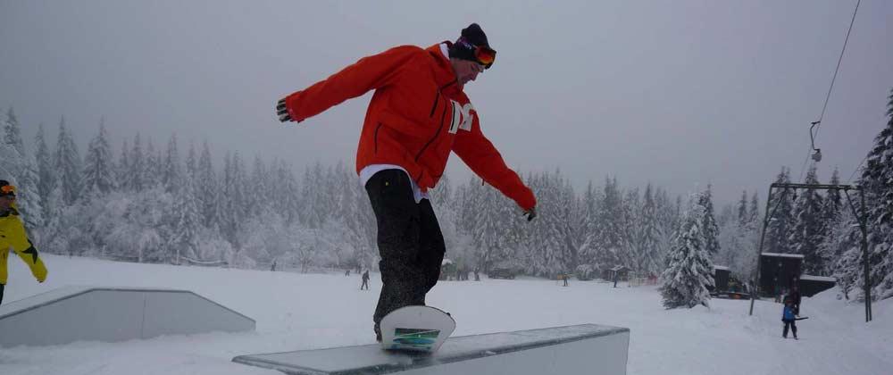 Snowboarder auf einen Rail im Snowpark Sonnenberg