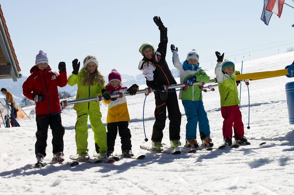 Kinder mit der Skilehrerin in der Skischule