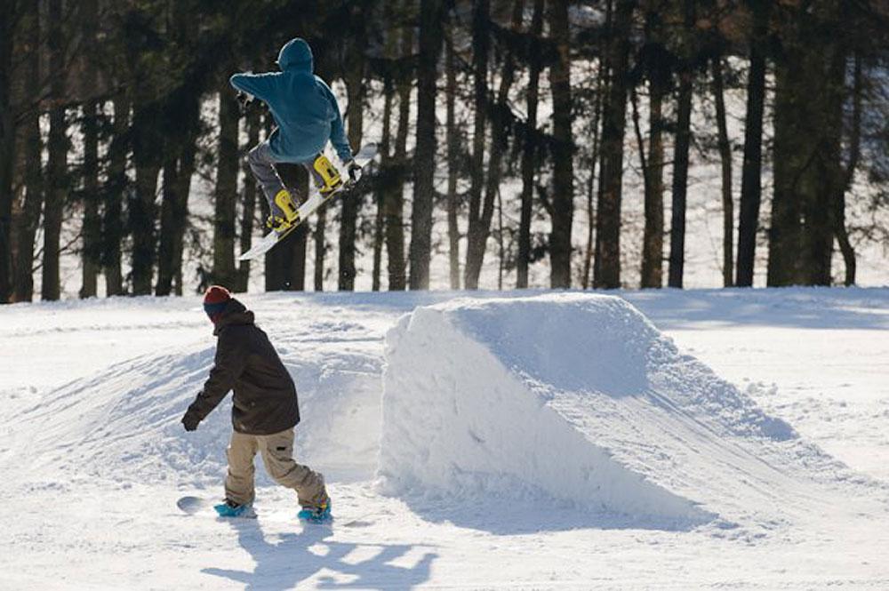 Snowboarder auf einem Kicker im Snowpark im Skigebiet Zuckerfeld