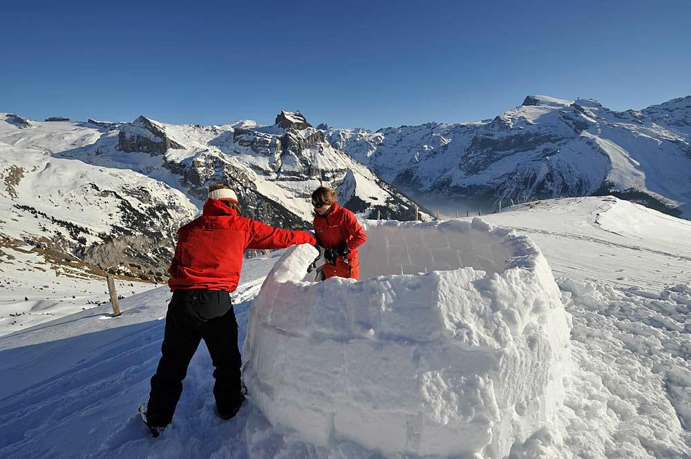Zwei Wintersportler bauen ein Iglu in Engelberg