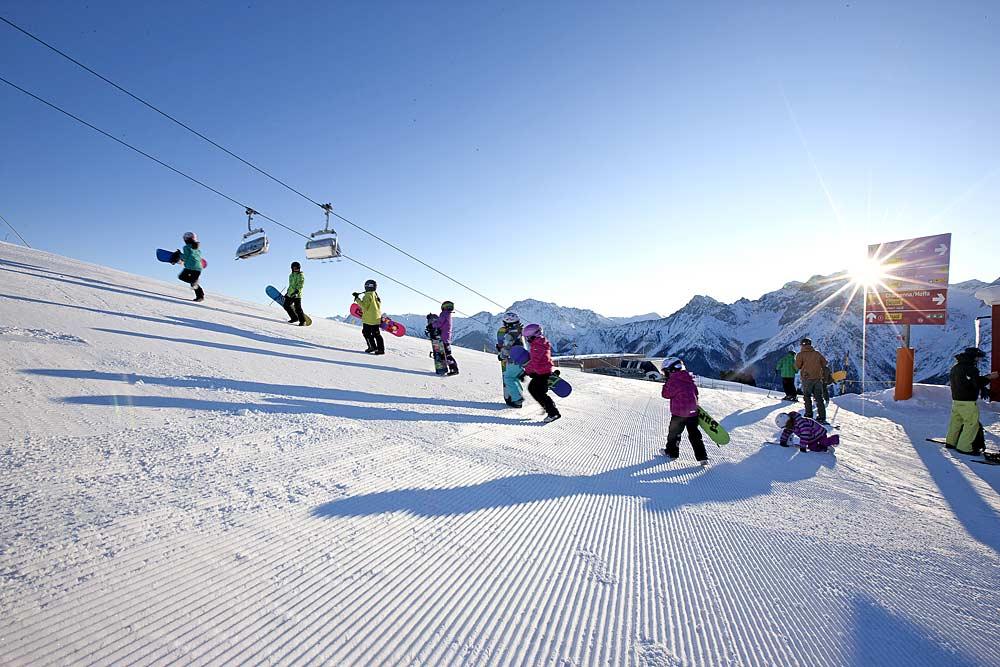 Kinder beim Snowboardkurs in Motta Naluns
