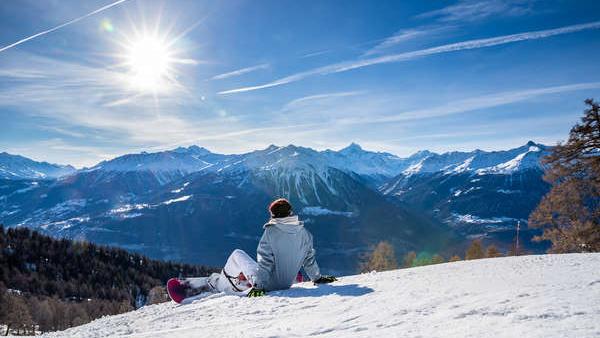 Snowboarder genießt Aussicht vom Skigebiet Jeizinen
