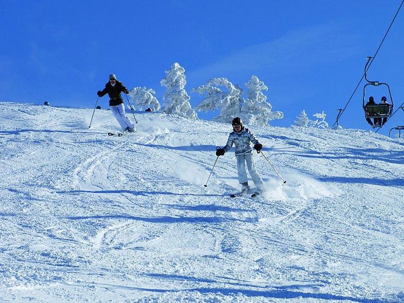 Zwei Skifahrer auf der Piste in Hochkössen