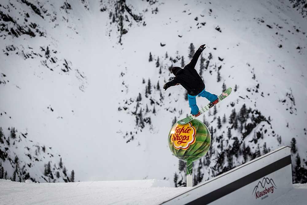 Snowboarder springt über Obstacle mit Riesenlutscher im Funpark Klausberg
