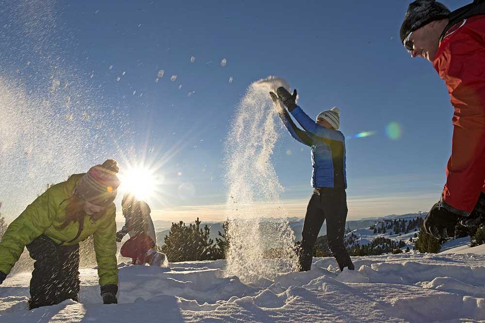 Familie spielt im Schnee auf der Plose