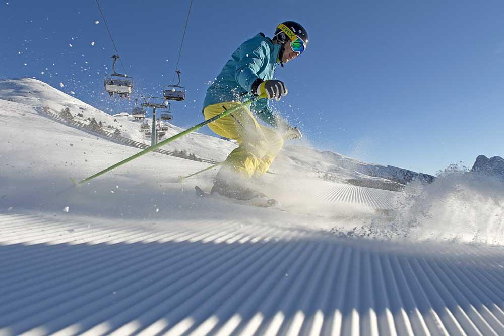 Skifahrer fährt auf einer Piste unter dem Sessellift in Brixen