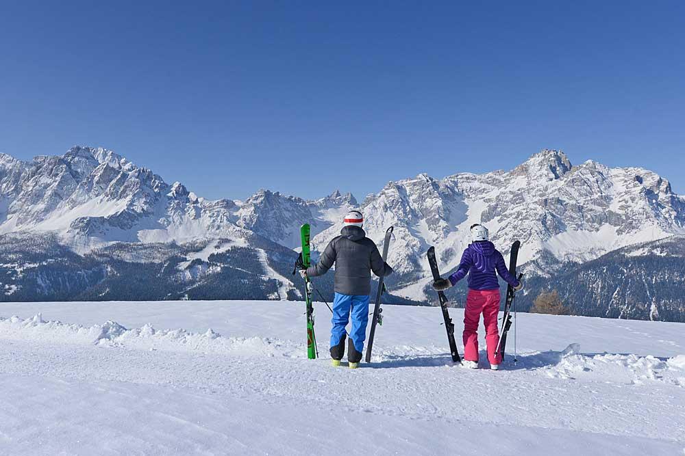 Zwei Skifahrer blicken auf die Berge der Sextner Dolomiten