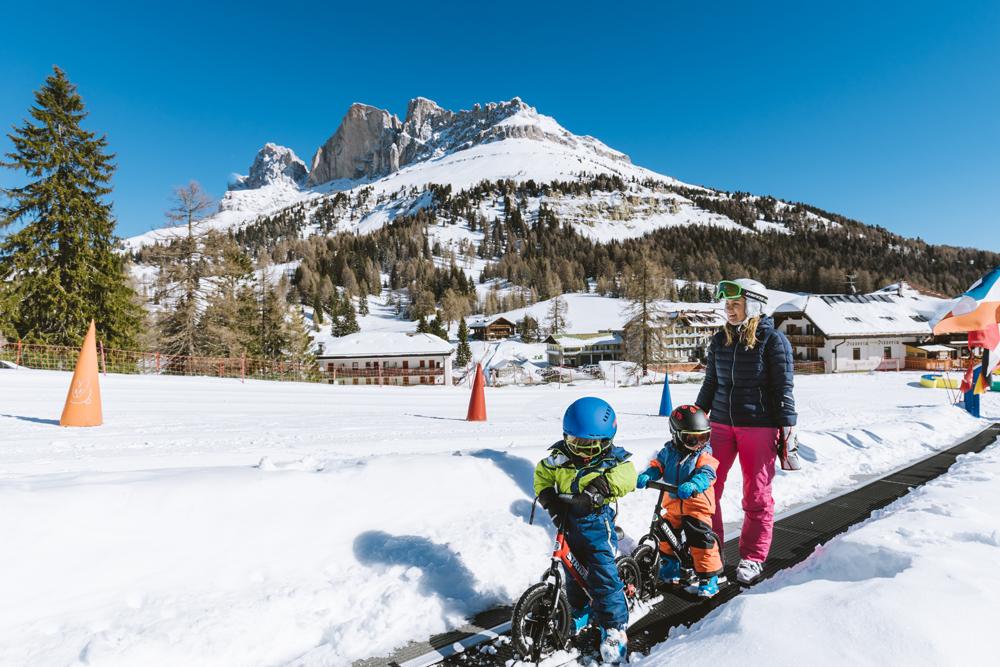 Kinder auf einem Förderbahn im Skigebiet Carezza