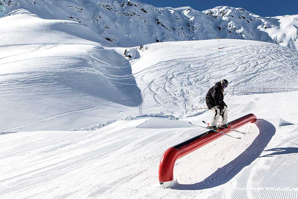 Skifahrer gleitet über Tube im Snowpark Speikboden