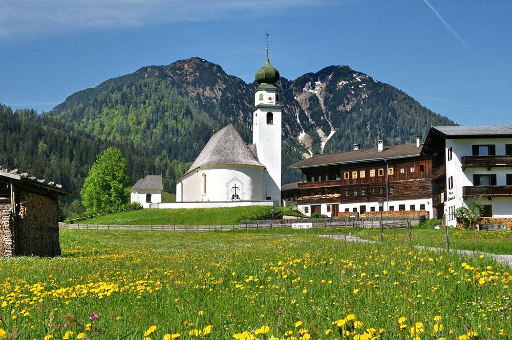 Blick auf die Kirche in Thierbach mit Gratlspitz im Hintergrund