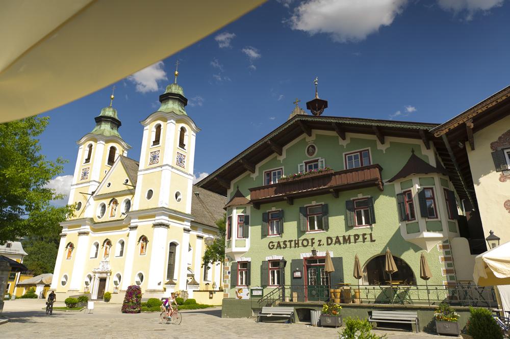 Ortszentrum von St. Johann in Tirol mit der mächtigen Dekanatskirche und dem Traditionsgasthof Zum Dampfl